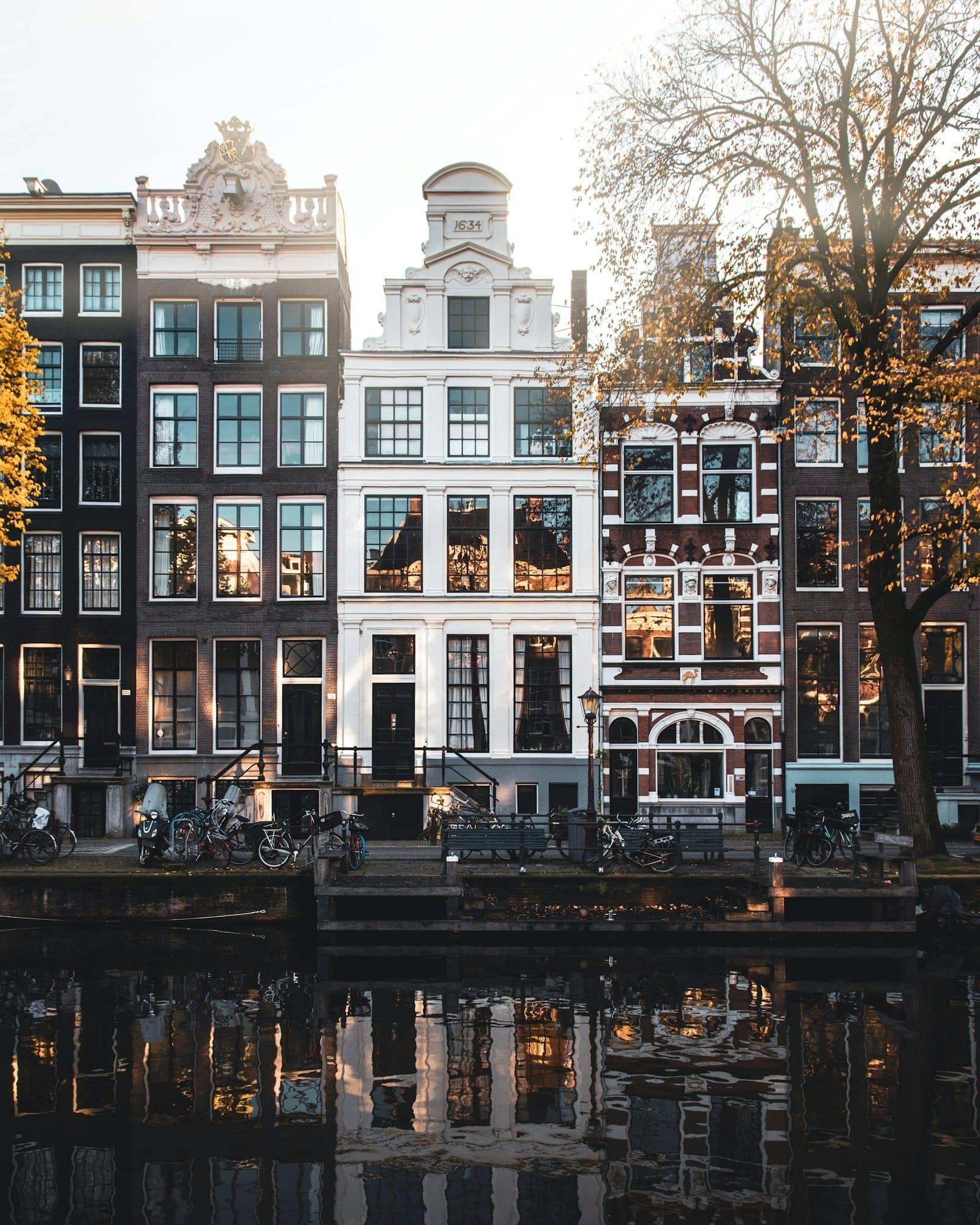 Tall canal houses in Amsterdam under a clear sky