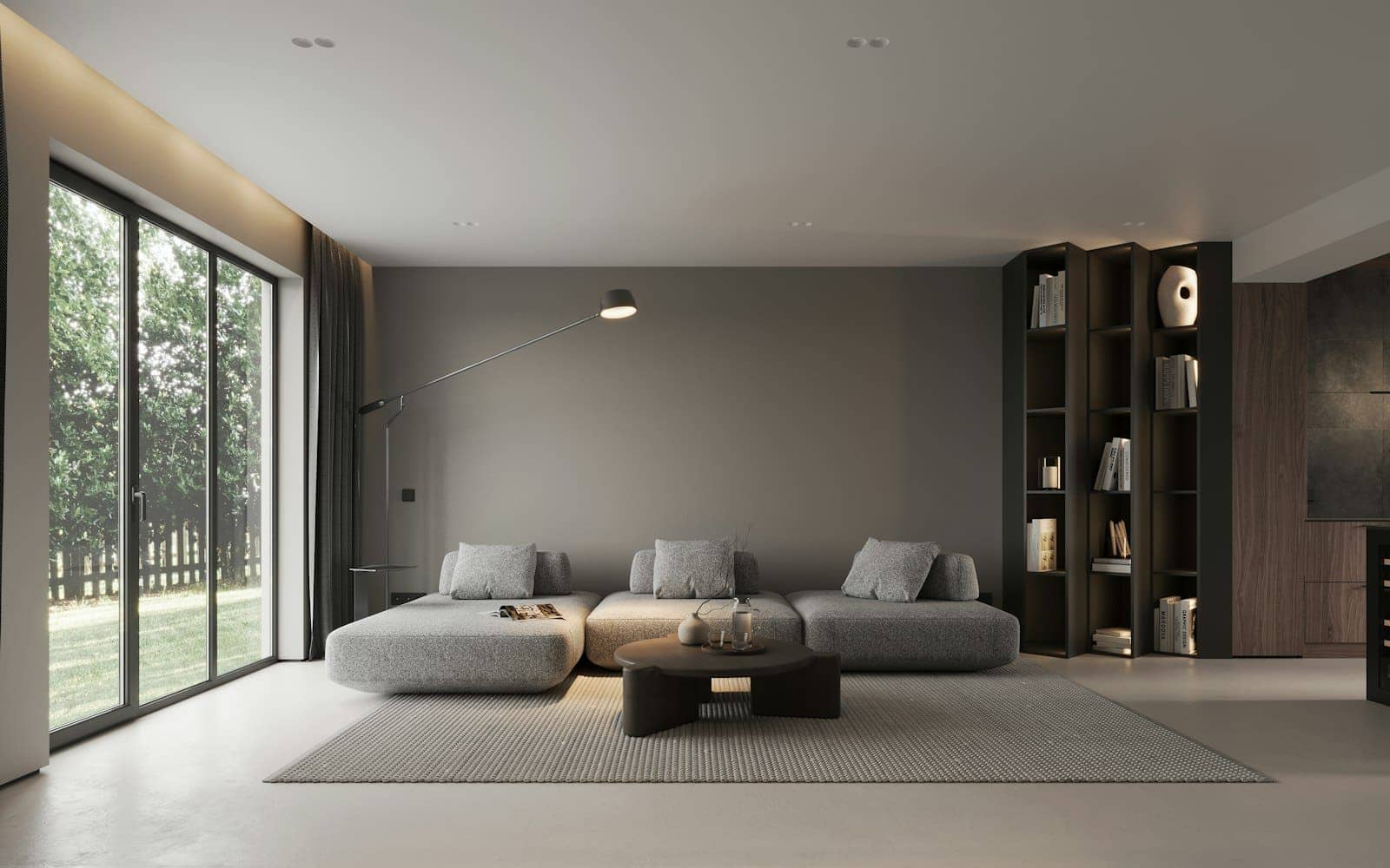 A minimal grey living room with a low sofa and bookshelves